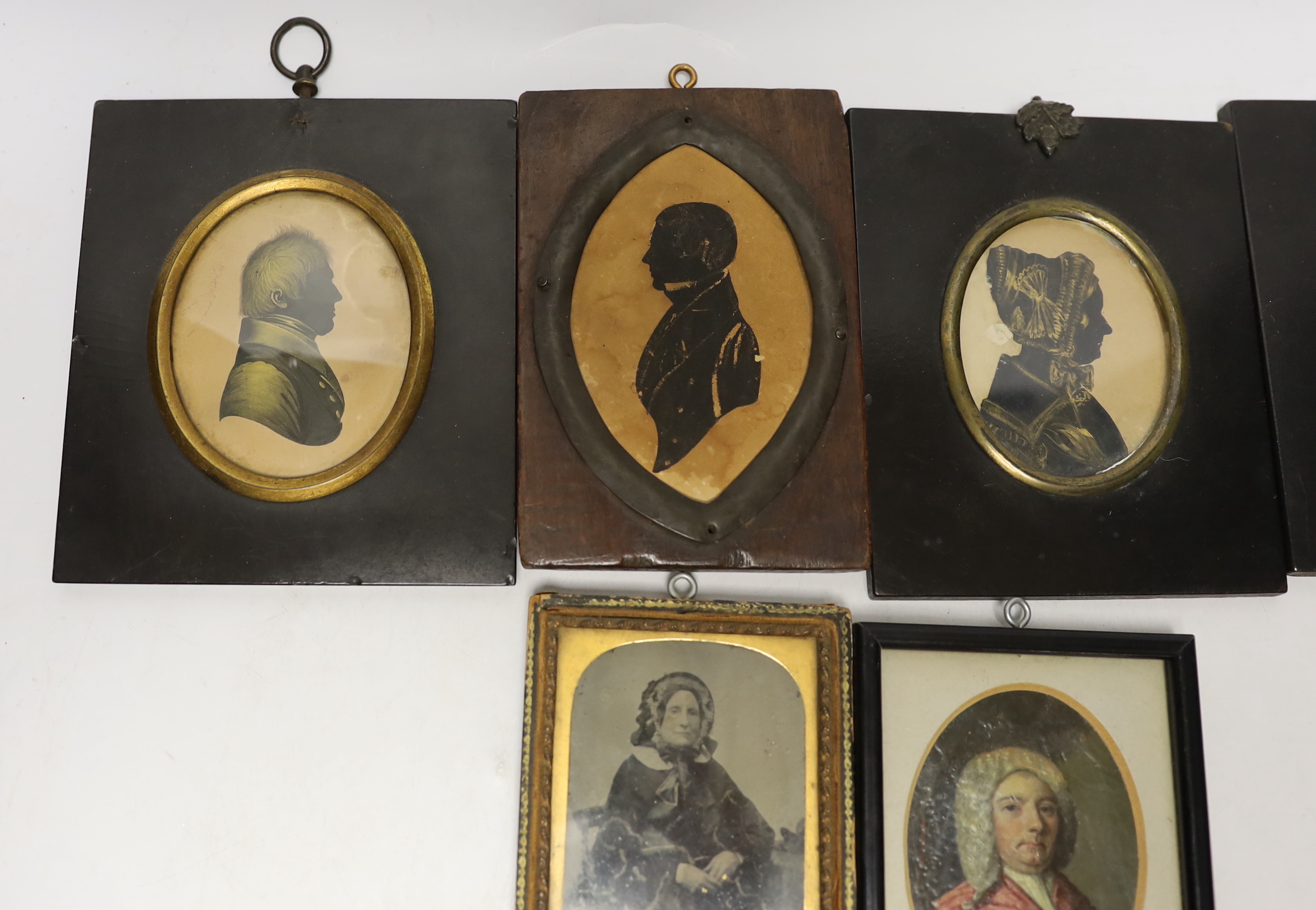 A quantity of miniatures comprising oil of an 18th century gentleman wearing a wig, three 19th century silhouettes, Victorian blue and white photograph and one other